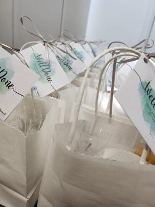 Printed Well Done gift bags lined up on a counter after a bakery session